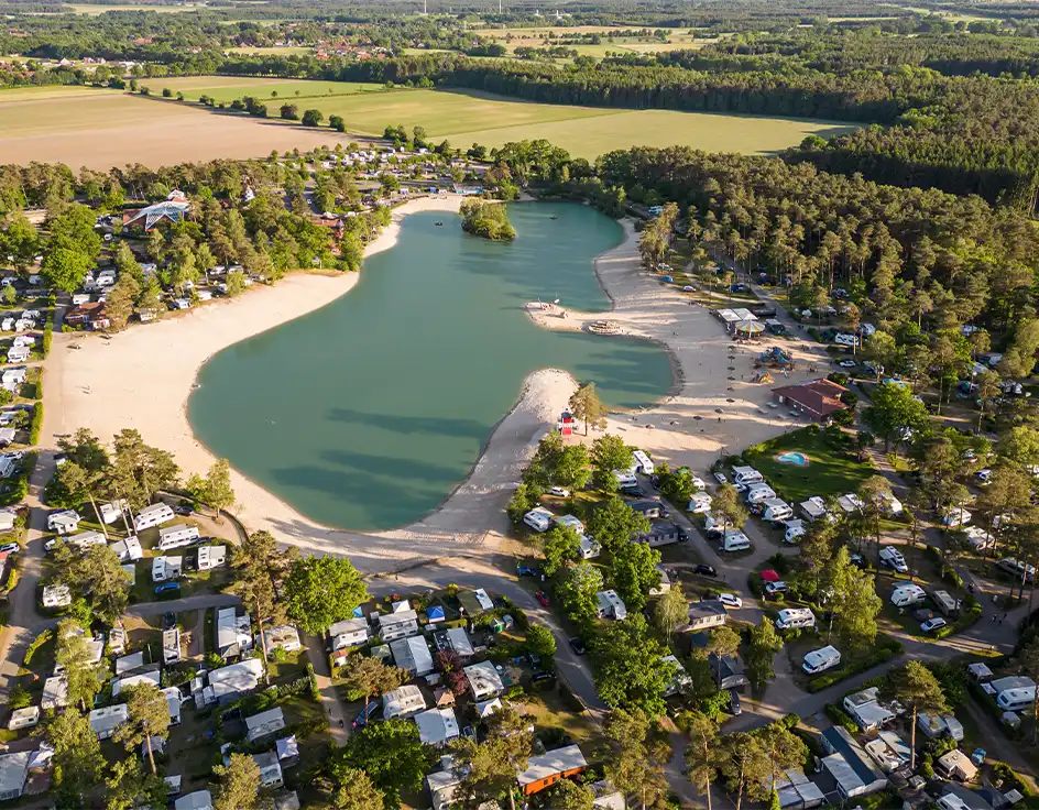 Jobs / Stellenangebote: Arbeiten im Südsee-Camp Luftaufnahme vom Südsee-Camp in der Lüneburger Heide mit großem Badesee, Sandstrand, Stellplätzen für Wohnwagen und Wohnmobile sowie umgebenem Wald – familienfreundlicher Campingplatz mit Natur und Freizeitangebot