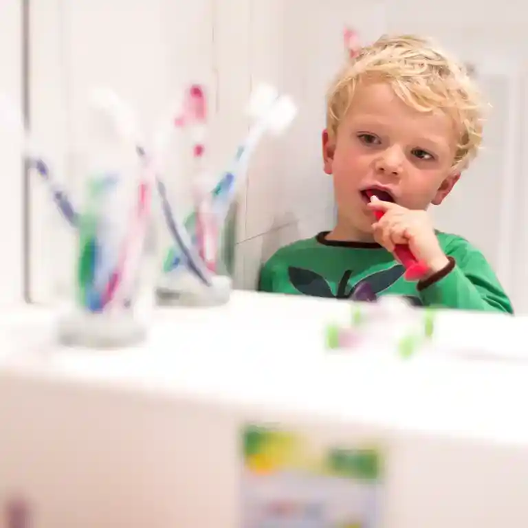 Little boy brushing his teeth in the children’s washroom at Südsee-Camp – toothbrush holders in the foreground, child-friendly sanitary facilities for families