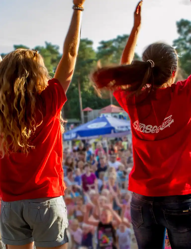 Animateurinnen auf der Bühne vor jubelndem Publikum beim Kinderprogramm