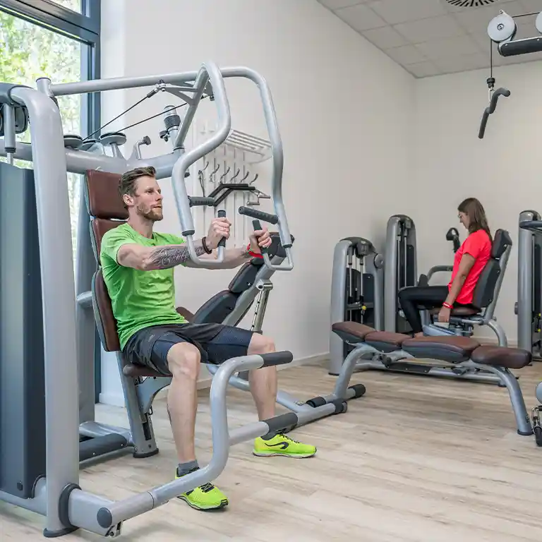 Bright, modern fitness room at Südsee-Camp with workout machines where family members of all ages can stay fit – accessible space for healthy vacation exercise.