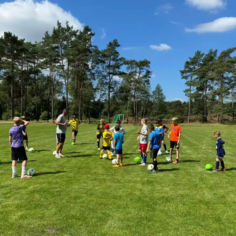 Kinder spielen auf grünem Rasen Fußball
