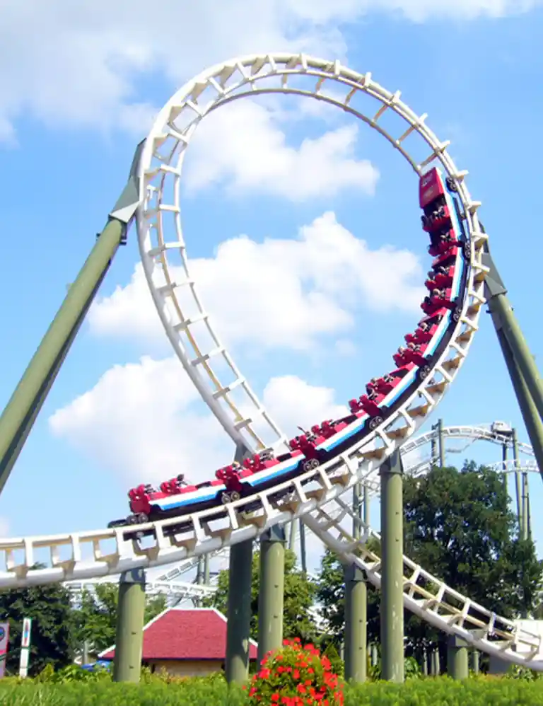 Roller coaster with a loop at Heide Park under a blue sky – thrilling amusement park fun for the whole family in Northern Germany’s largest theme park.