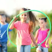 Hula hoop Girl with hula hoop in her hand, children in the background