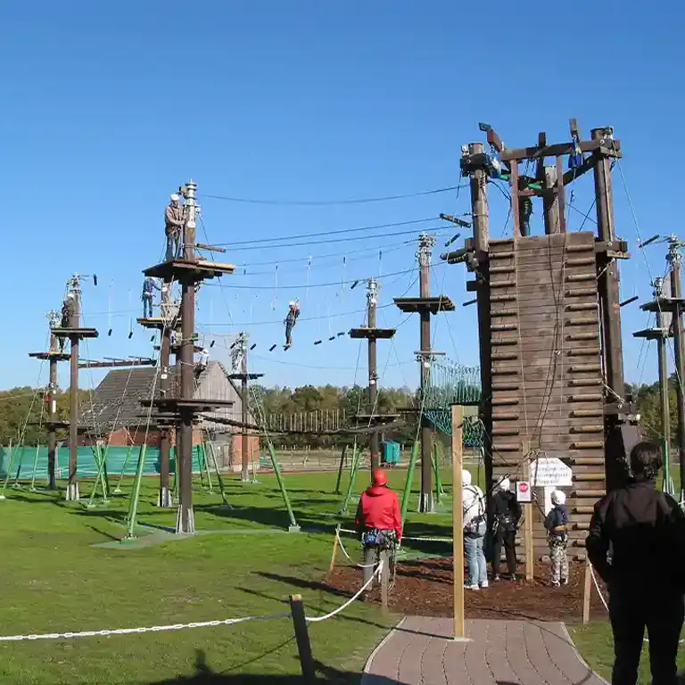 Abenteuerlicher Hochseilgarten im Südsee-Camp: Kinder und Erwachsene klettern gesichert über Seile, Plattformen und Brücken in luftiger Höhe. Eine spannende Freizeitaktivität für Familien und Abenteuerlustige.