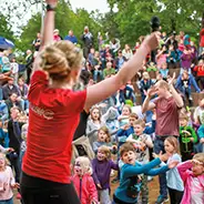 Pentecost female Südsee-Camp entertainer on stage in front of a crowd of children