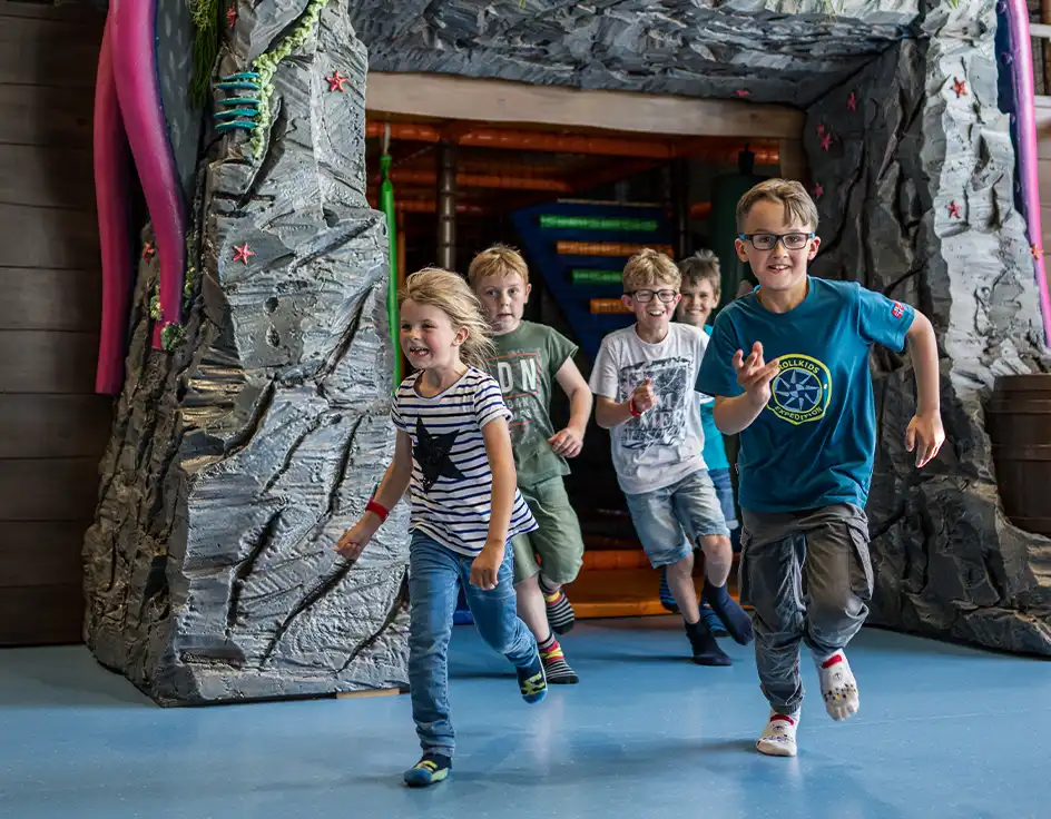 Children running and laughing out of a themed indoor play area at Südsee-Camp – fun, activity, and adventure for the whole family.