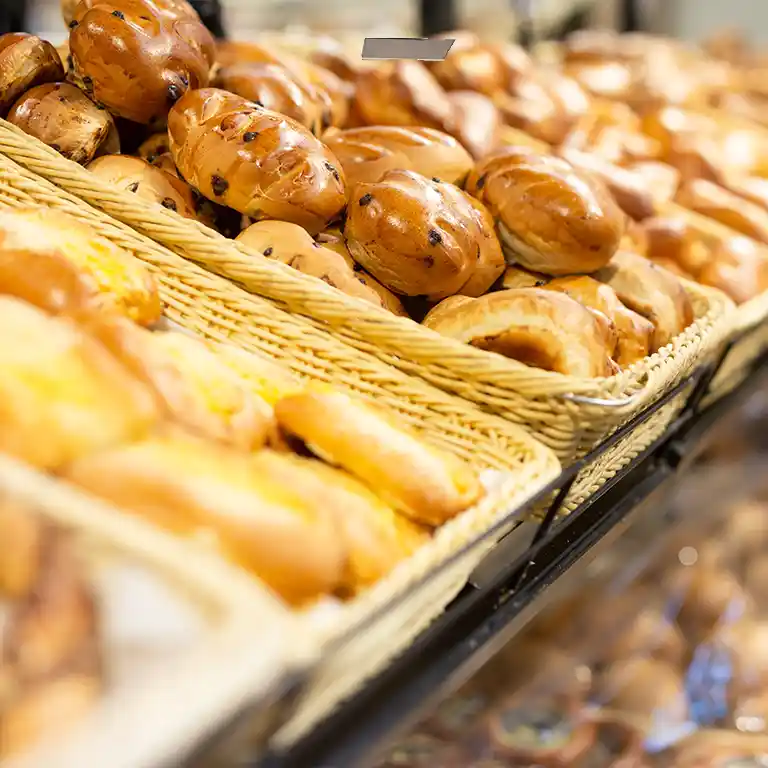 Freshly baked bread rolls and sweet pastries in woven baskets at the Südsee-Camp bakery – perfect for a family-friendly holiday breakfast.