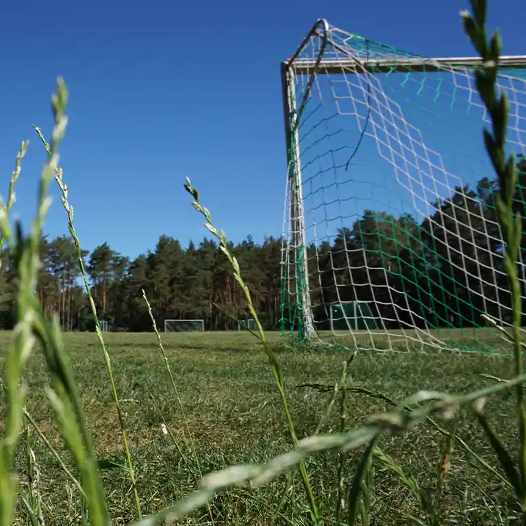 Football field at Südsee-Camp under clear blue skies – perfect for kids, teens, and families; spacious area, easily accessible and suitable for all age groups.