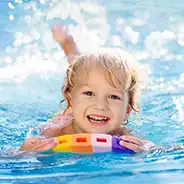 Schwimmen lernen: Mädchen planscht im Wasser